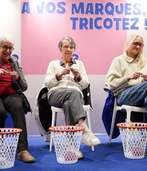 Participantes prenant part à un atelier de tricot collectif lors d’un événement créatif