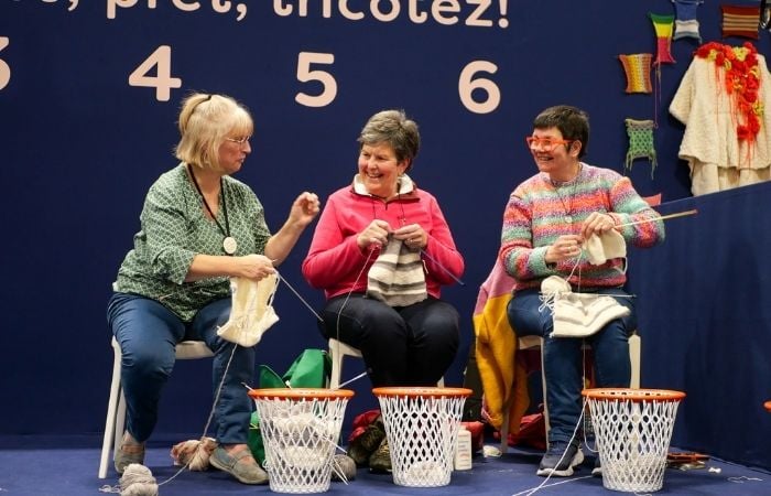 Participantes prenant part à un atelier de tricot collectif lors d’un événement créatif