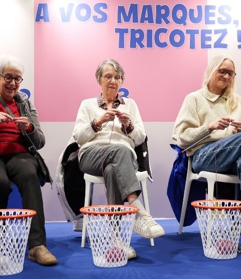 Participants in a group knitting workshop at a creative event