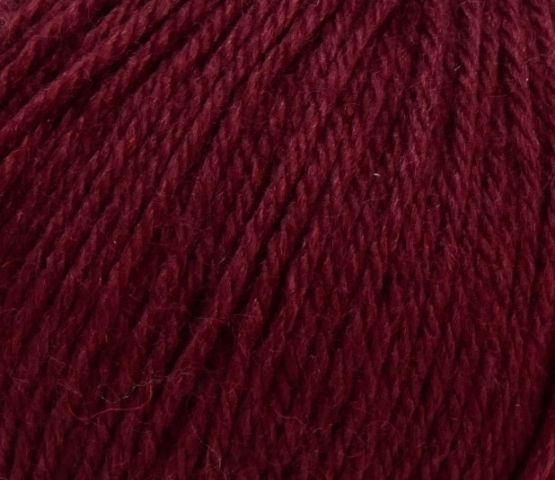 Fil de laine en rouge profond, représentant un produit de qualité pour le tricot.