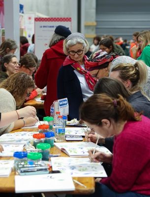 Participants concentrés sur un atelier de peinture et loisirs créatifs en salon