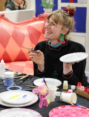 Femme souriante peignant des objets décoratifs lors d’un atelier créatif DIY