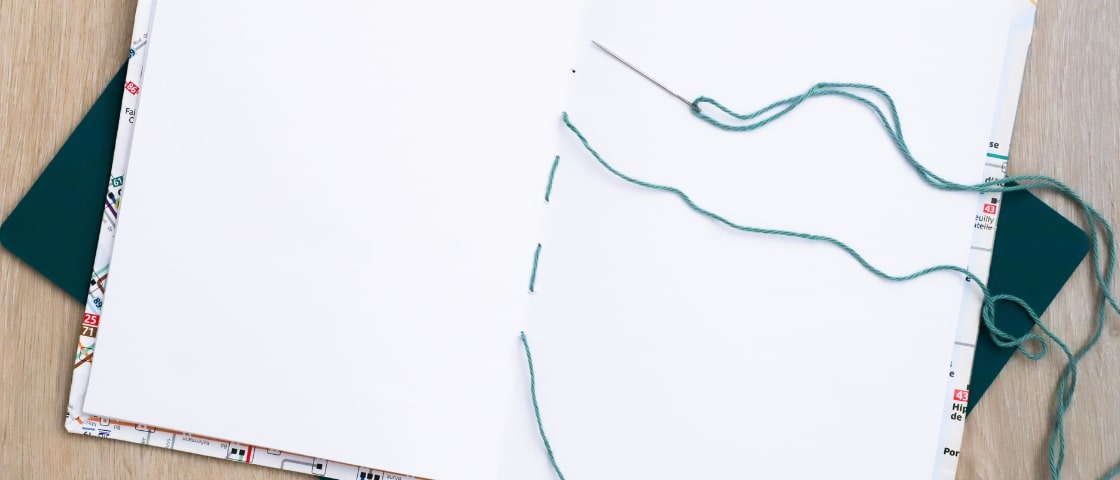 Sewing the edge of a handmade DIY travel diary
