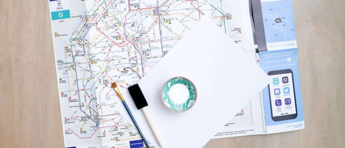 Matériels pour carnet de voyage DIY fait main : plan de métro, papier, pinceau...