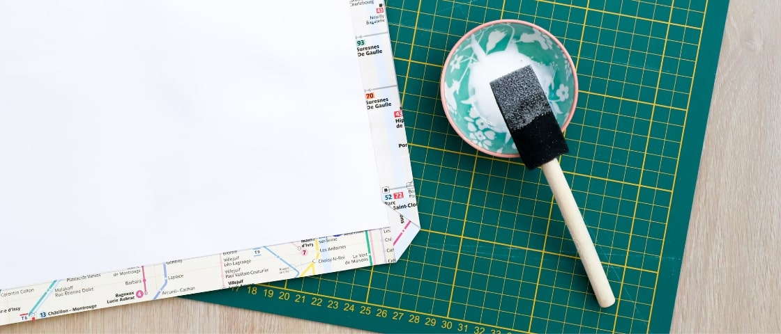 Handmade DIY travel diary materials: metro map, pot of glue and paintbrush