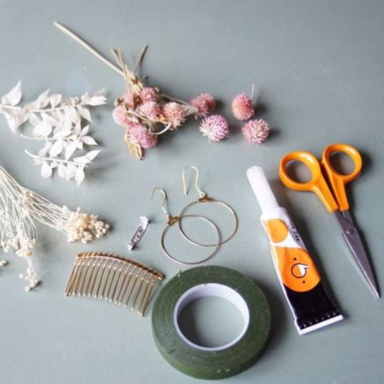 Ensemble de matériel pour réaliser des bijoux en fleurs séchées : ciseaux, colle, fleurs, fil de fer, peigne, boucles.