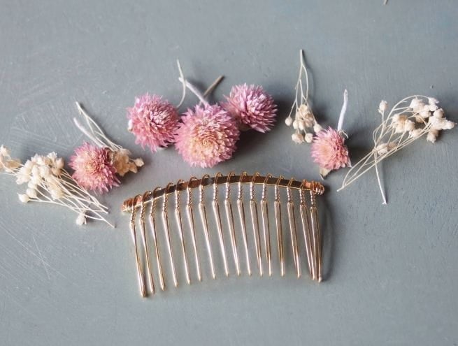 Peigne doré, fleurs séchées et ciseaux préparés pour l’atelier DIY.