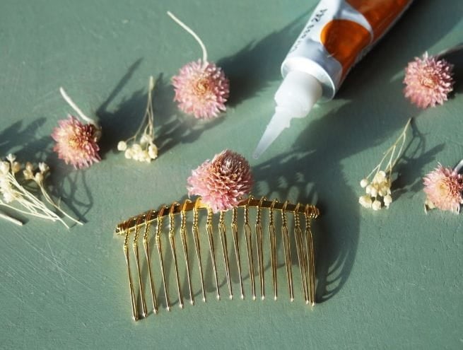 Début de collage de fleurs séchées sur le peigne doré.