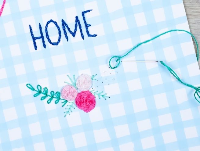 Finition de broderie sur papier avec motif floral et mot HOME.