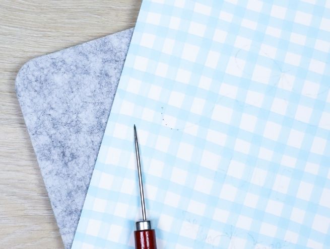 Perçage du papier avec une aiguille pour préparer la broderie.