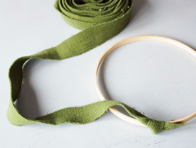 Étape 3 de la couronne de Noël, le tissu vert est enroulé autour du cercle en bois.