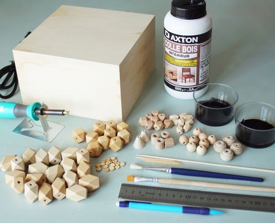 Matériel pour fabriquer un jeu d'échecs : boîte en bois, pièces géométriques, pinceaux, colle et règle