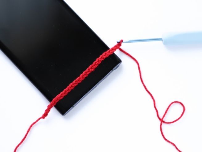 Première étape du tutoriel de crochet pour réaliser une pochette de téléphone avec un fil rouge