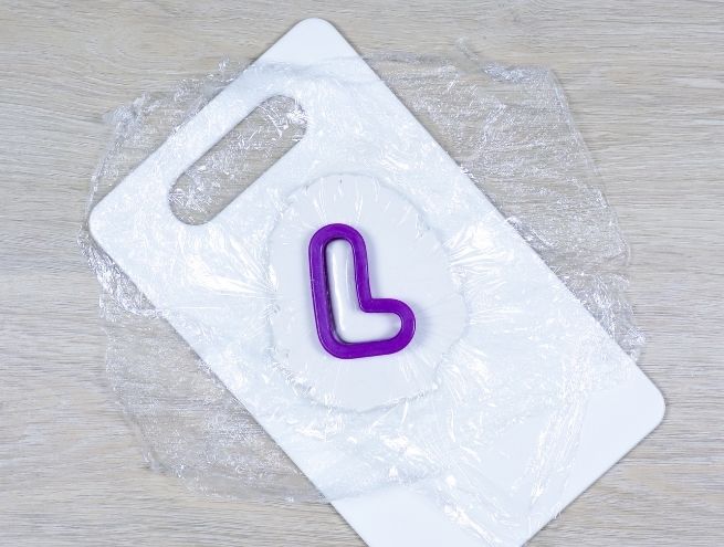 Decoupe d’une lettre en forme de coeur dans la pate autodurcissante avec un emporte-piece.