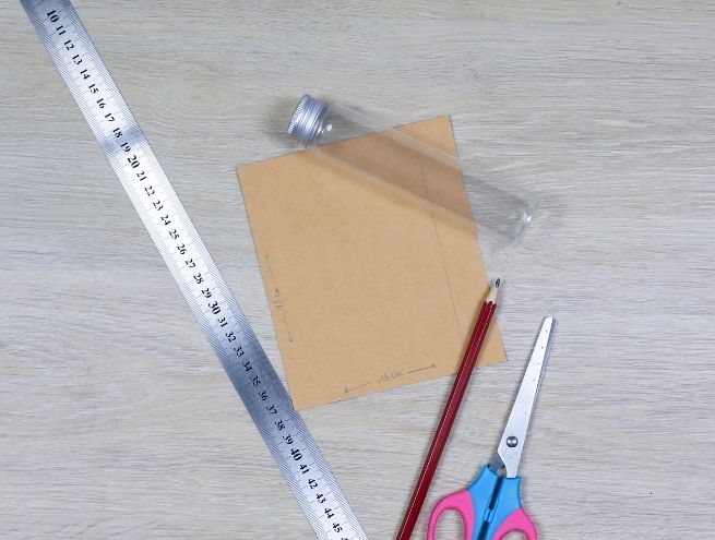 Trace et mesures sur carton recycle avec regle et crayon pour realiser un vase DIY.