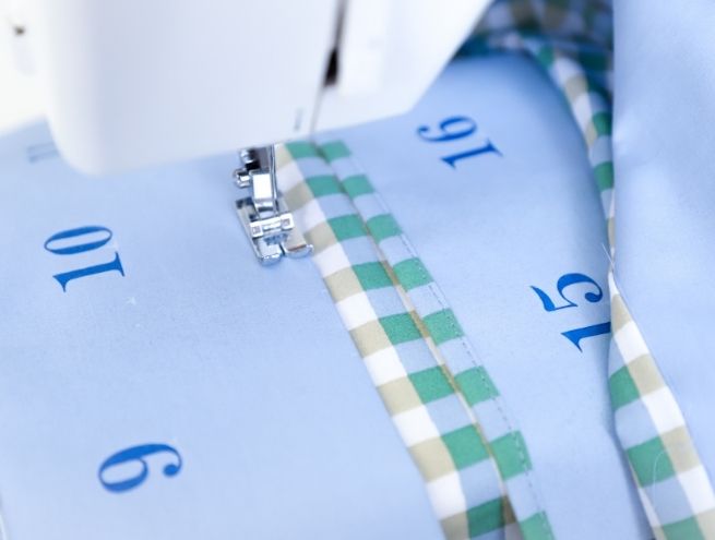 Couture d'une finition en tissu vichy sur le bord d'une poche du calendrier de l'Avent