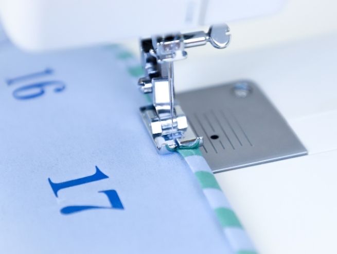 Couture d'une finition en tissu vichy sur le bord d'une poche du calendrier de l'Avent
