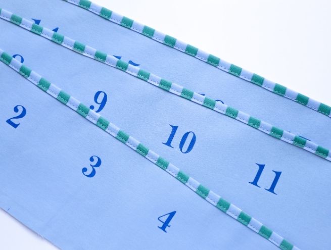 Découpe précise des bandes de tissu pour réaliser les poches du calendrier de l'Avent