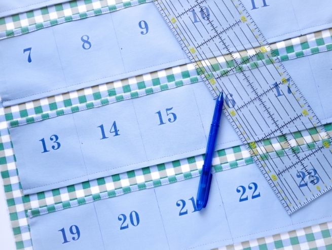 Mesure des bandes de tissu du calendrier de l'Avent avec une règle de couture