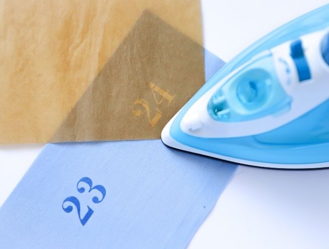Repassage d'une bande de tissu pour préparer les finitions du calendrier de l'Avent