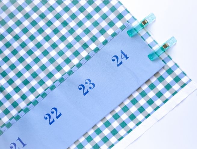 Fixation des bandes de tissu sur le calendrier de l'Avent avec des pinces de couture