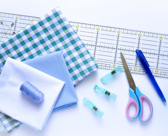 Matériel de couture pour fabriquer un calendrier de l'Avent en tissu, avec tissus, ciseaux, règle et pinces