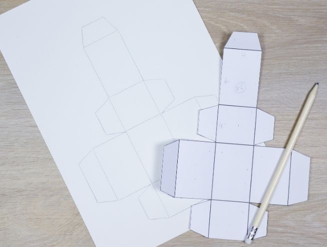Étape de découpe des gabarits en papier pour créer les boîtes du calendrier de l’Avent herbier.