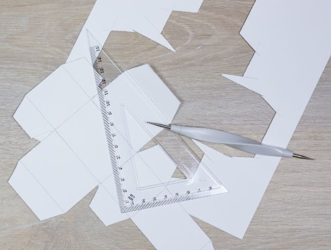 Traçage et découpe des formes du calendrier de l’Avent herbier avec règle et plioir.