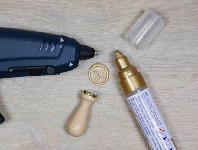 Personnalisation des boîtes du calendrier de l’Avent avec pistolet à colle et cire dorée.