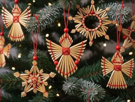 Décorations traditionnelles en paille en forme d'anges et d'étoiles suspendues sur un sapin de Noël.