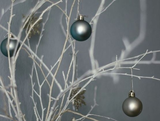 Sapin de Noël minimaliste décoré de boules argentées et de décorations en teal.