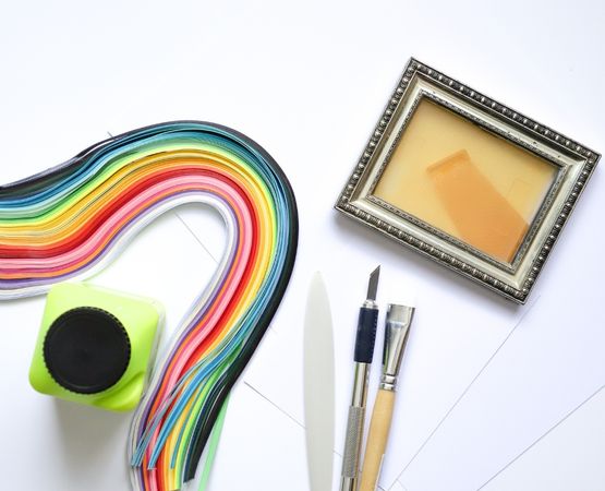 Bandes de papier colorées et outils de découpe pour un atelier de marqueterie papier DIY