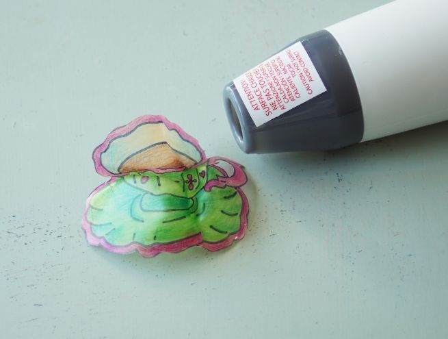 Découpage des dessins de broches en plastique avec un cutter et des ciseaux.