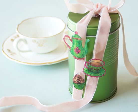 Broches en plastique décorées de dessins colorés de théière, tasse et cupcake.