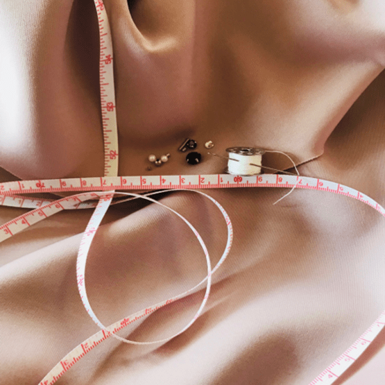 Nécessaire de couture : fil, épingle, aiguille, tissu rose, ruban, mètre