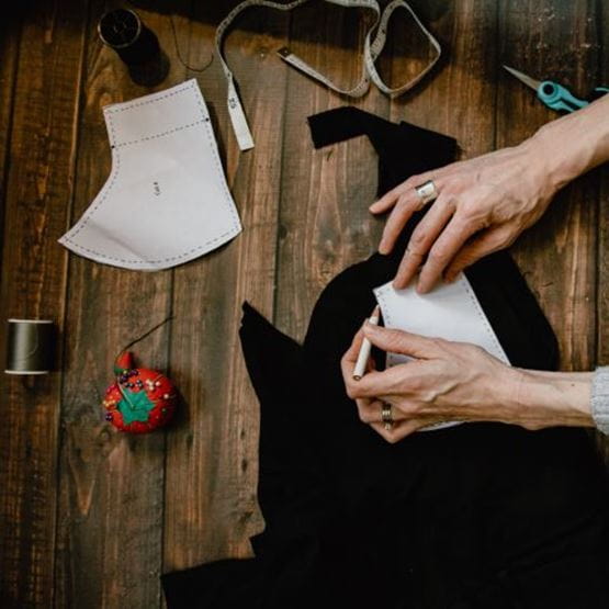 Une couturière place son patron de couture sur son tissu.