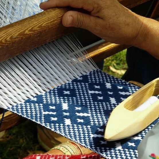 Conseils de tissage avec outils et fils colorés sur une table en bois.