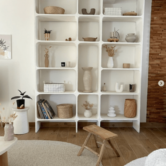 Étagère blanche au design arrondi avec objets de décoration d’inspiration scandinave.