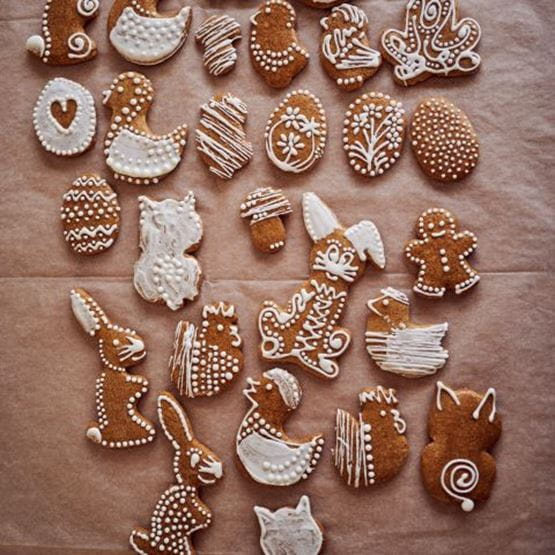 Ensemble de biscuits de Pâques en pain d’épices décorés de glaçage blanc représentant des œufs, lapins, poussins et canards.