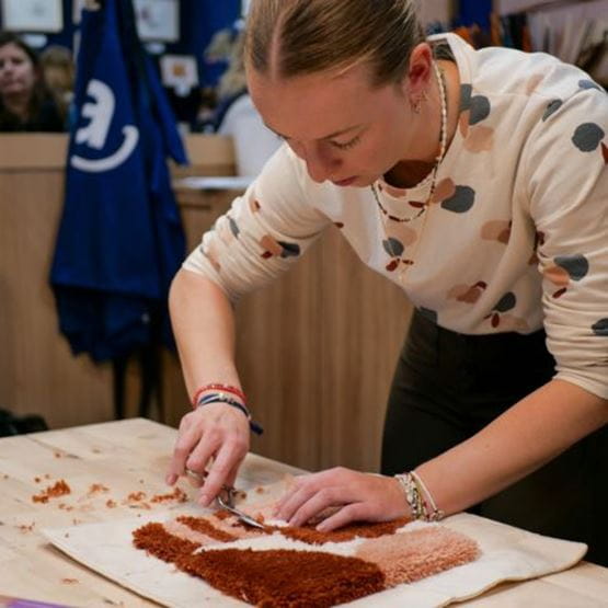 Femme réalisant un atelier DIY de tufting sur Créations & Savoir-faire 2024
