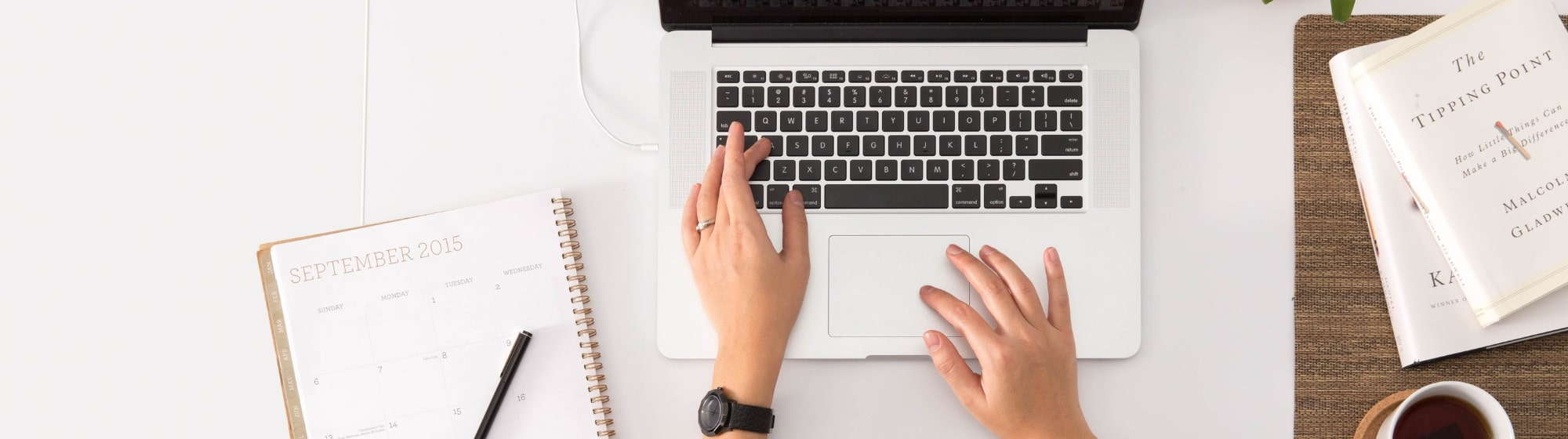 A woman types on a laptop keyboard