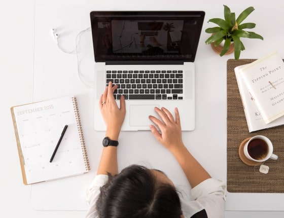 Une femme tape sur le clavier d'un ordinateur portable